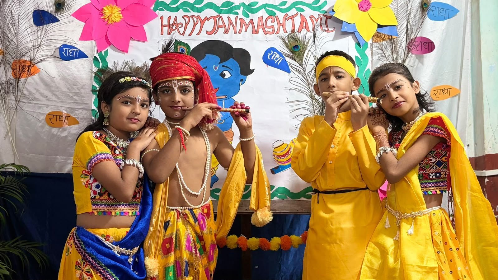 Four students in Krishna and Radha costumes at the Janmashtami celebration